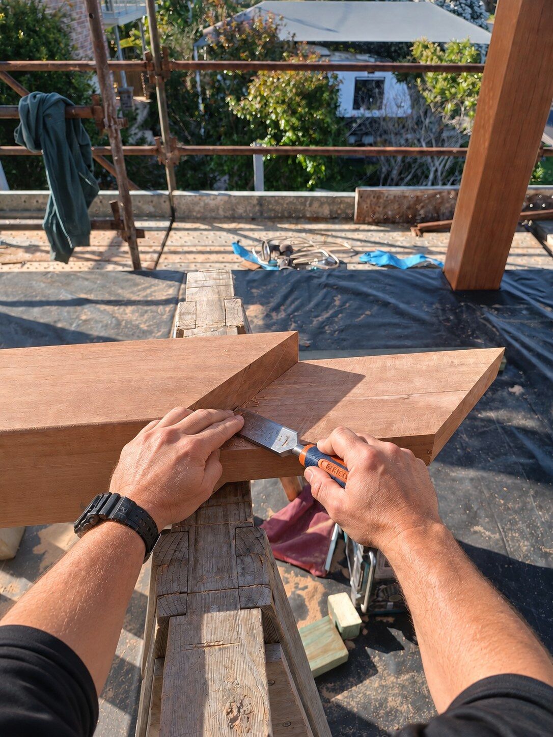 A hardwood beam joint being pared by hand with a chisel