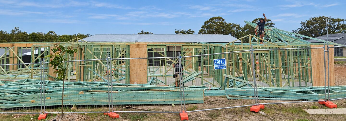 A timber house frame and roof trusses standing on a residential build site