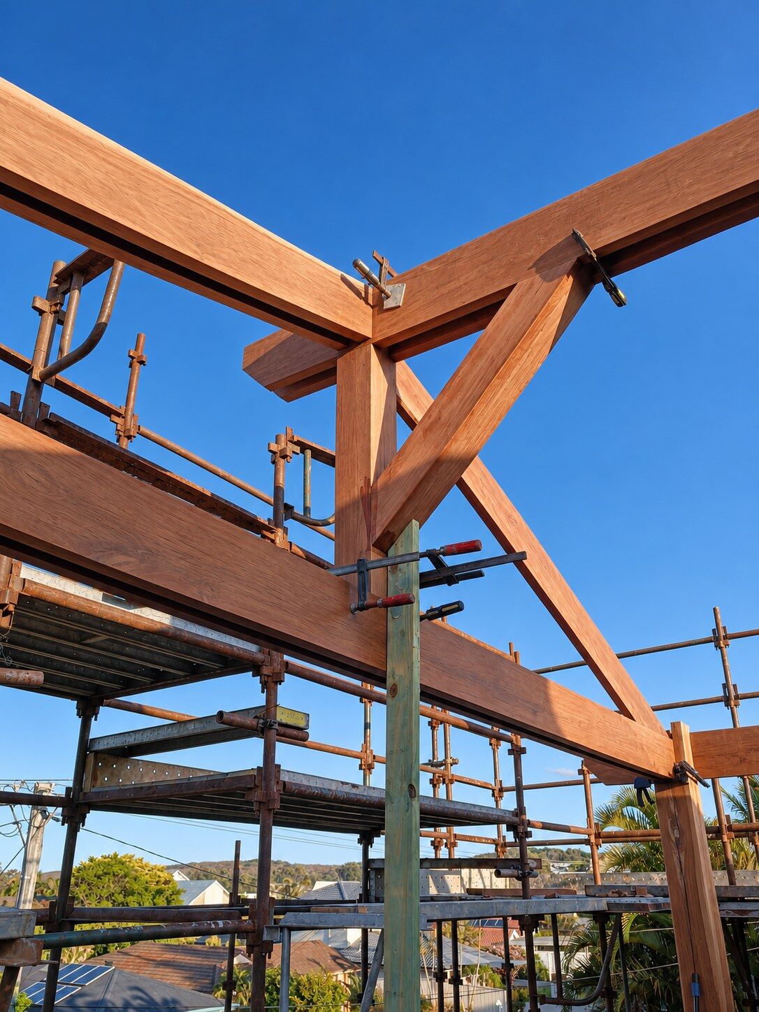 An exposed hardwood post and beam junction clamped in place